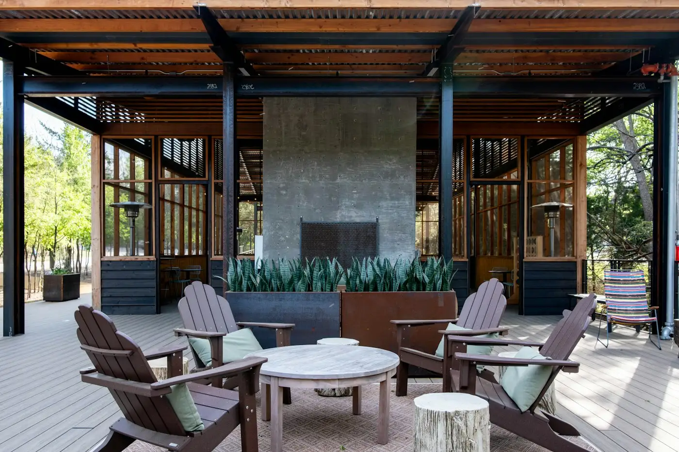 Covered outdoor patio with a fireplace and chairs